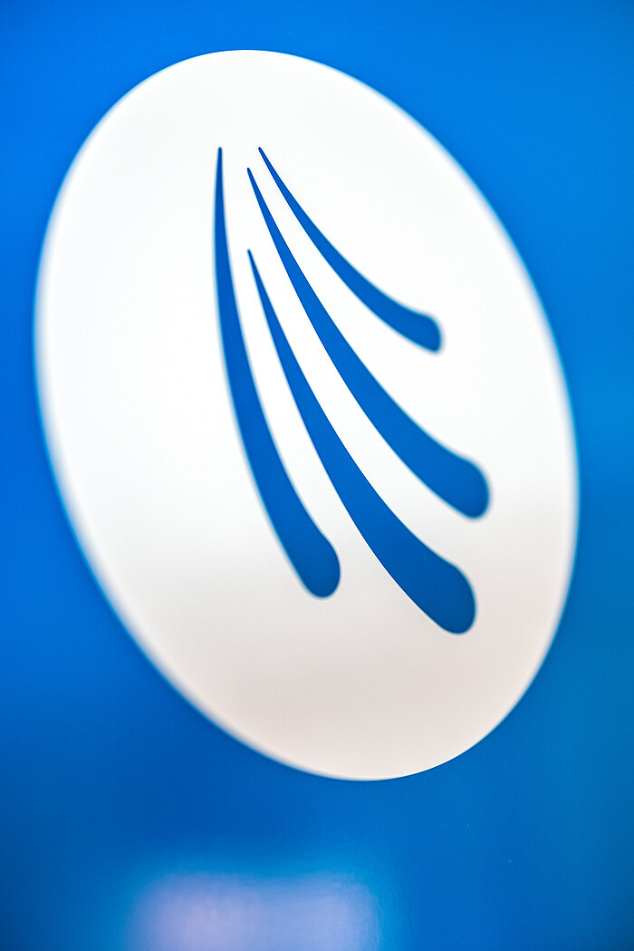 Logo der Arztpraxis Dr. Markus Ruch in Triberg: Weißes Logo mit stilisierten geschwungenen Linien auf einem blauen Hintergrund. Die Linien verlaufen in abgerundeter Form und vermitteln einen Eindruck von Bewegung und Dynamik.